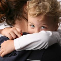 A parent holding a child. C4c is testing a European paediatric clinical trial network.