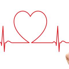 A person drawing an ECG style link with a red pen. Part of the line is shaped like a heart. Image by LeventeGyori via Shutterstock.