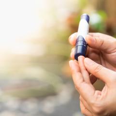 A woman pricks her finger to check her blood sugar levels. Image by Montri Thipsorn via Shutterstock.