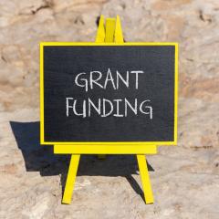 'Grant Funding' written in chalk on a little blackboard. Image by Dmitry Demidovich via Shutterstock.