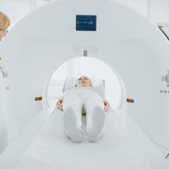 A woman undergoing a PET (positron emission tomography) scan, viewed from her feet. Image by Gorodenkoff via Shutterstock