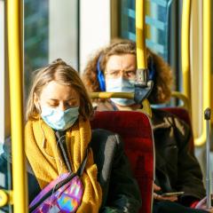 People on a tram wearing masks. Image by Orso via Shutterstock. 