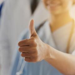 A health worker giving a thumbs up sign. Image by Syda Productions via Shutterstock