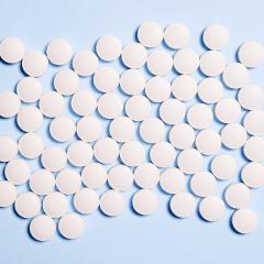 Round white pills on a pale blue background. Image by Anna Shvets via Pexels.