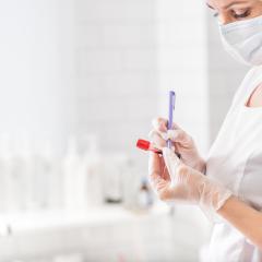 Woman writing on a blood test vial. Credits: lena Yakobchuk via Shutterstock