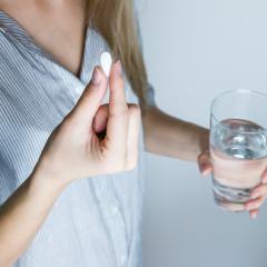 Woman takes a painkiller. Image courtesy of jeshootscom via Pexels