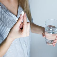 Image courtesy of jeshootscom via Pexels Woman takes a painkiller. Image courtesy of jeshootscom via Pexels